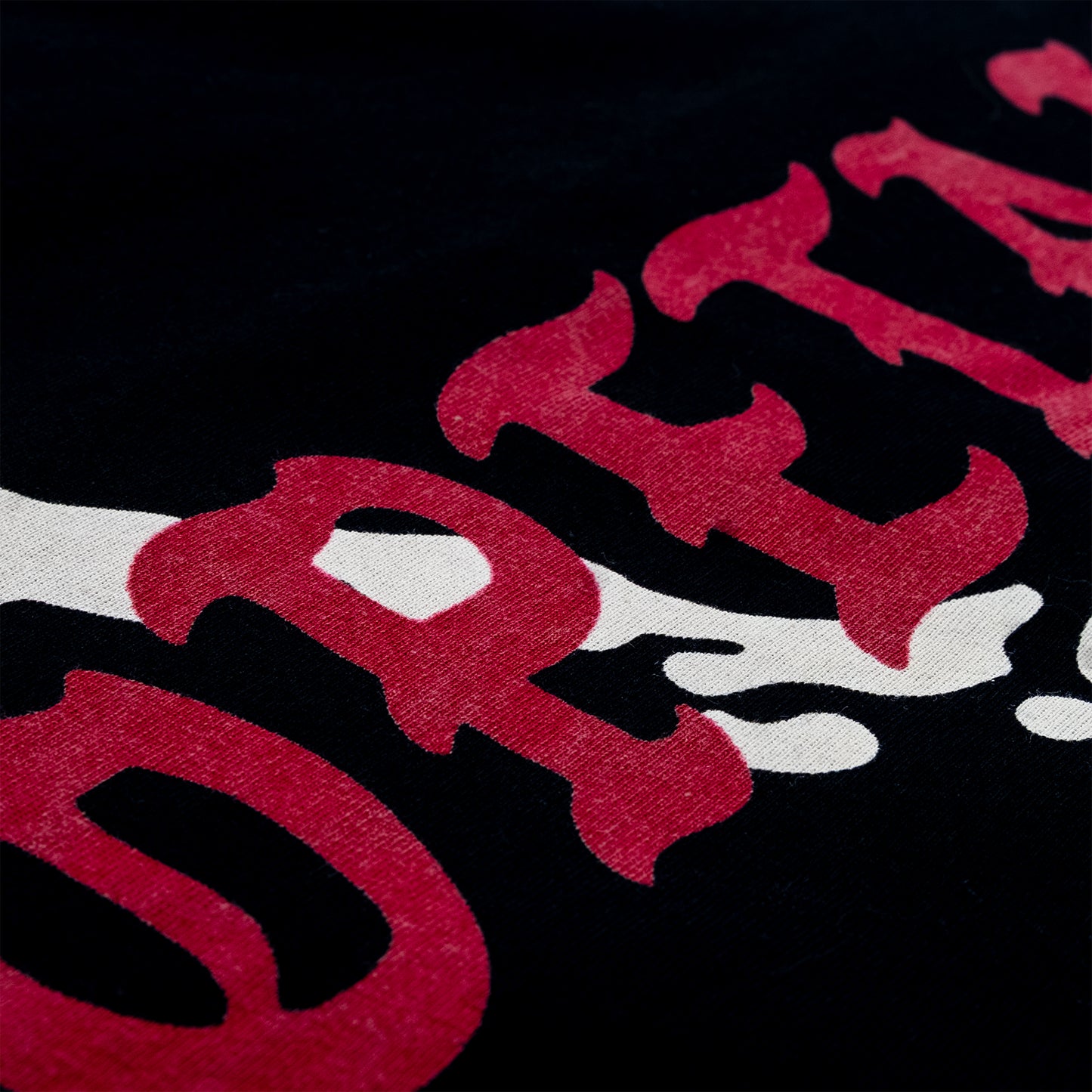 Close-up of a black fabric surface with large red and white graphic lettering.