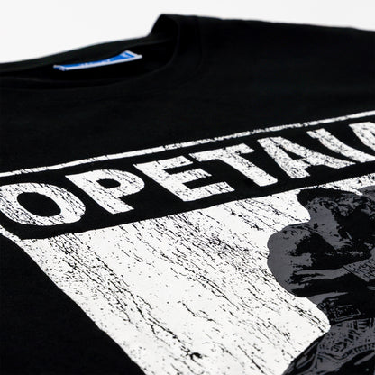 Close-up of a black T-shirt with a large distressed white graphic print reading 'OPETAIA' and a black-and-white portrait graphic on the front.