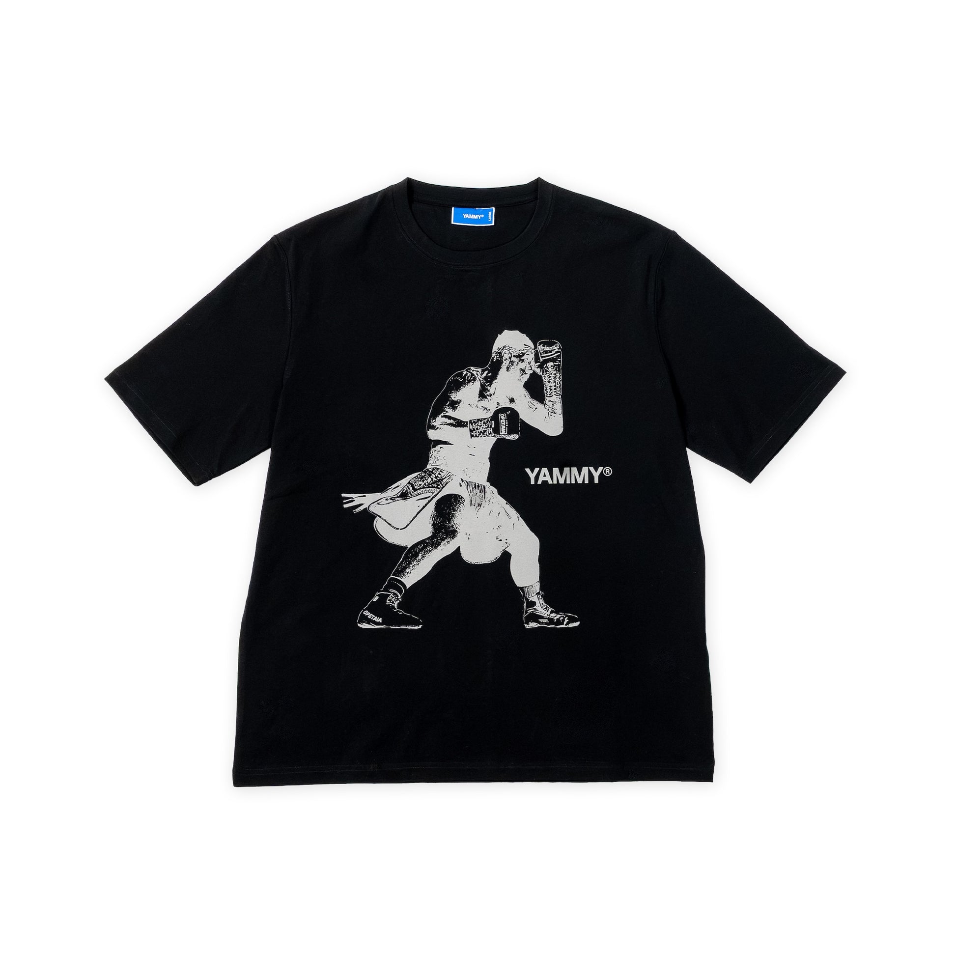A black short-sleeve t-shirt with a white graphic print of Jai Opetaia and the text 'YAMMY' on the front, displayed flat against a white background.