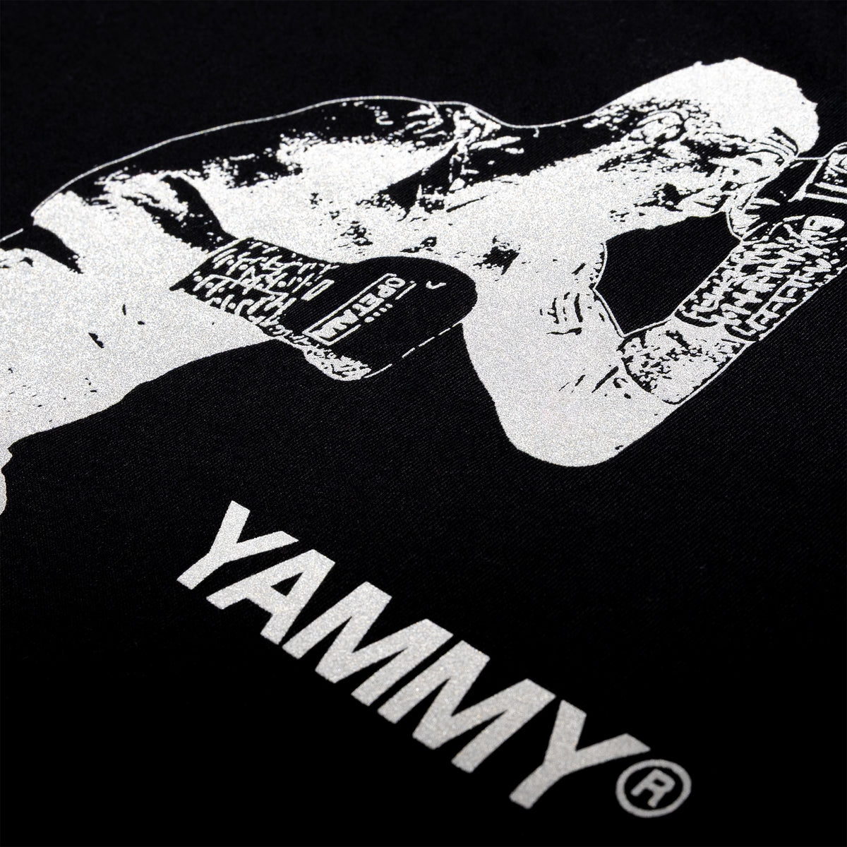 Close-up of a black T-shirt featuring a high-contrast white graphic of a fighter wearing gloves, with the word 'YAMMY' printed in large white letters below.