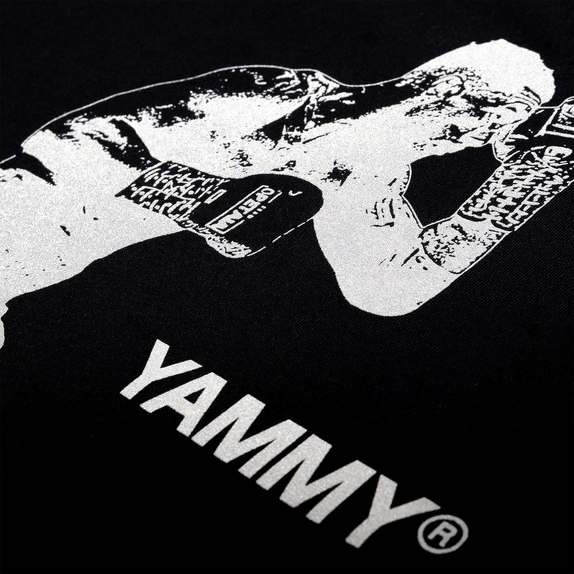 Close-up of a black T-shirt featuring a high-contrast white graphic of a fighter wearing gloves, with the word 'YAMMY' printed in large white letters below.