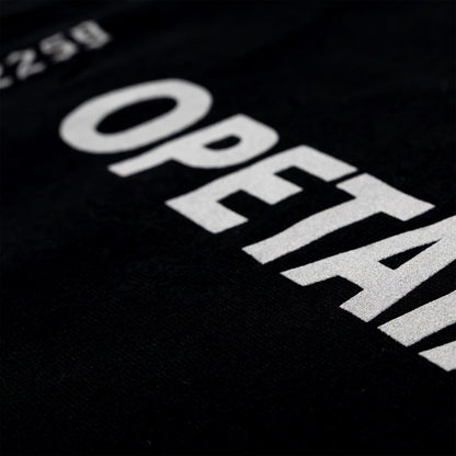 Close-up of a black garment with large white printed text reading 'OPETA' and partial numbers at the top left.