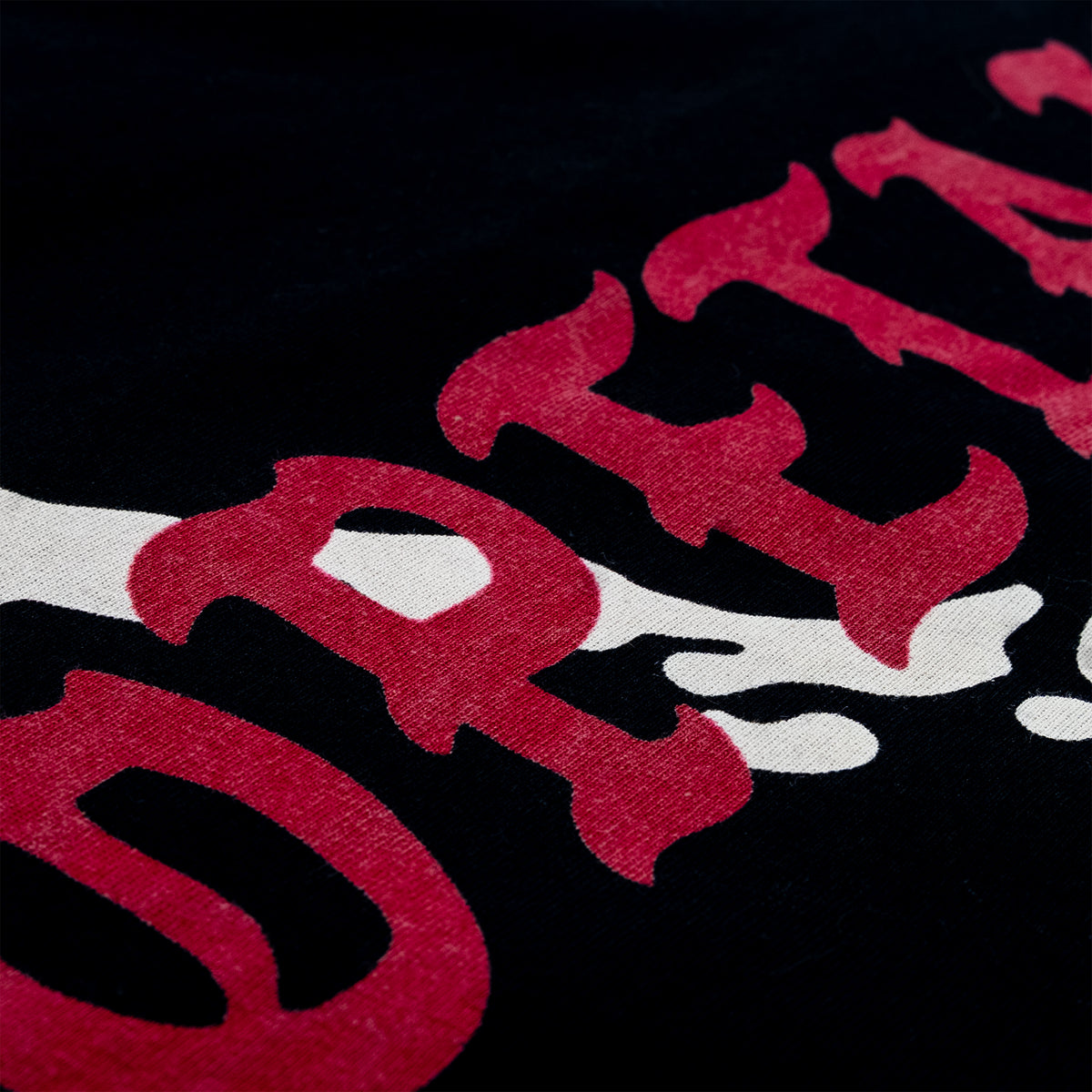 Close-up of a black fabric surface with large red and white graphic lettering.