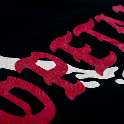 Close-up of a black fabric surface with large red and white graphic lettering.