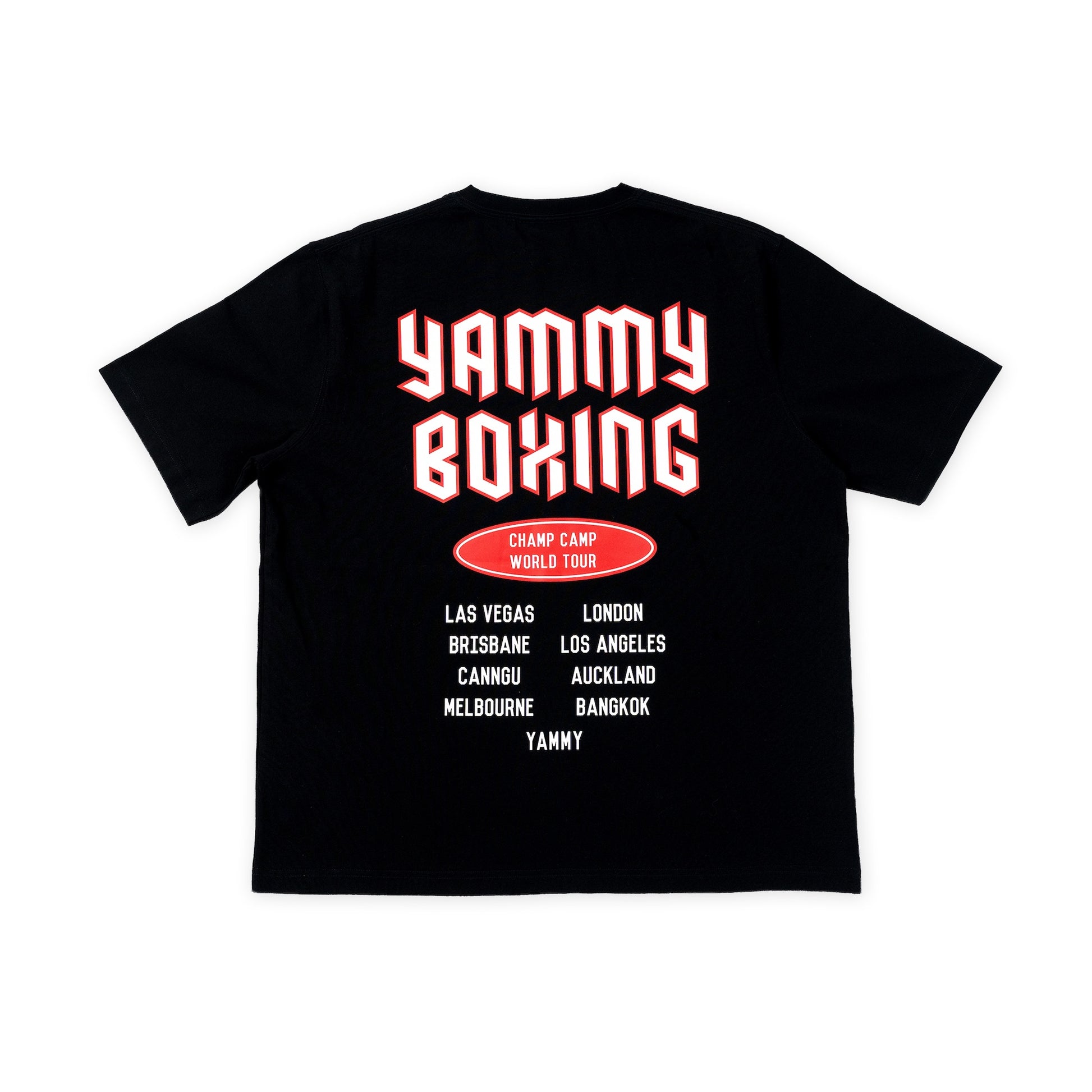 A black short-sleeve t-shirt shown flat against a white background, featuring a graphic print on the back with the words 'YAMMY BOXING' in large red and white bubble letters, a red oval badge reading 'CHAMP CAMP WORLD TOUR', and a list of travel destinations in white text.