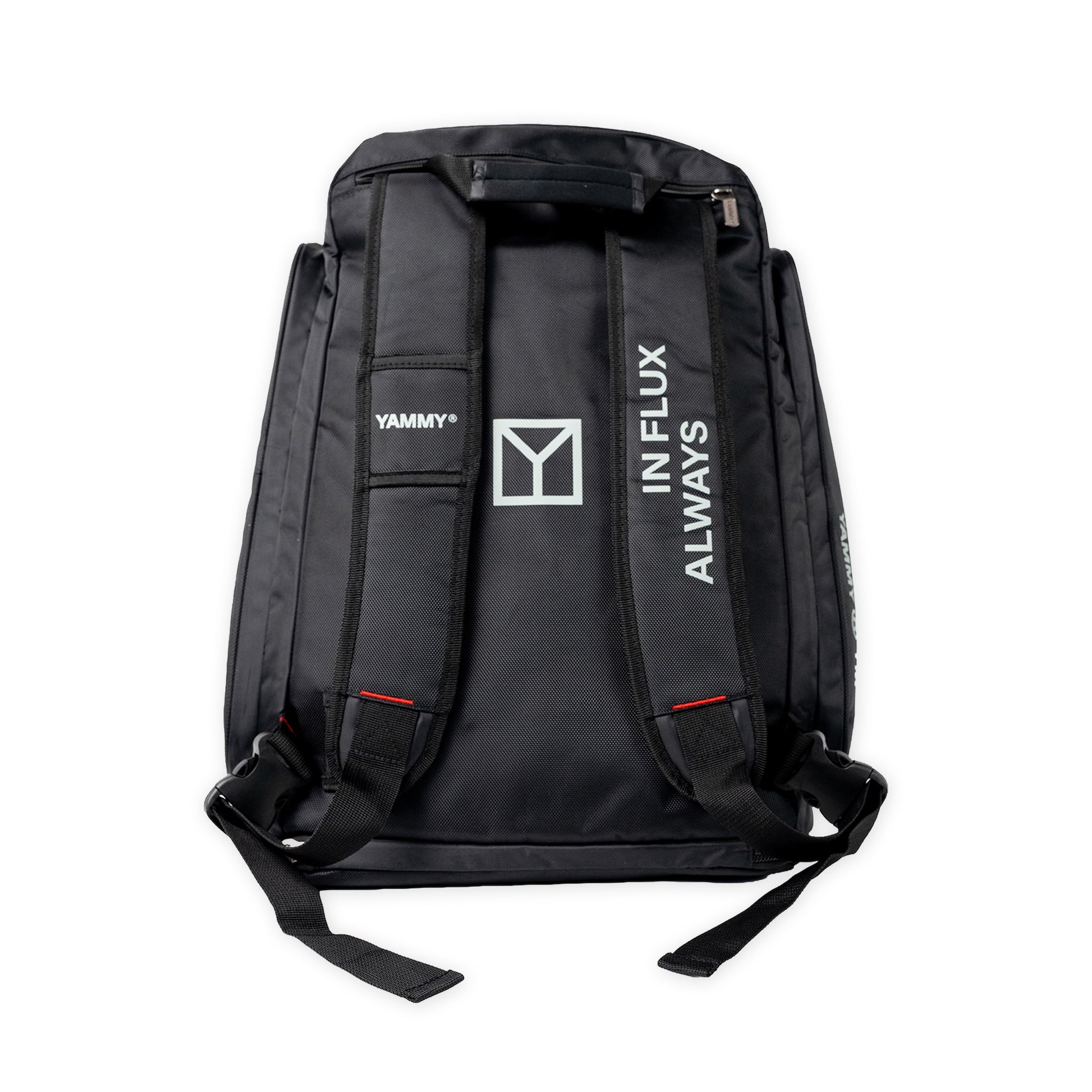 Black backpack shown from the back, featuring white printed branding including 'YAMMY', a large Y logo, and 'ALWAYS IN FLUX' on the shoulder straps, set against a plain white background.