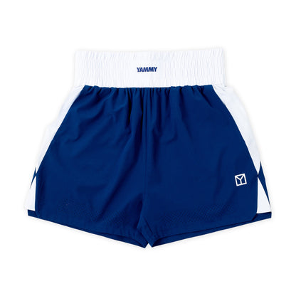 A pair of athletic shorts in navy blue and white, featuring a white elastic waistband with the brand name 'YAMMY' printed in navy, white side panels, and a small white logo on the lower left leg.