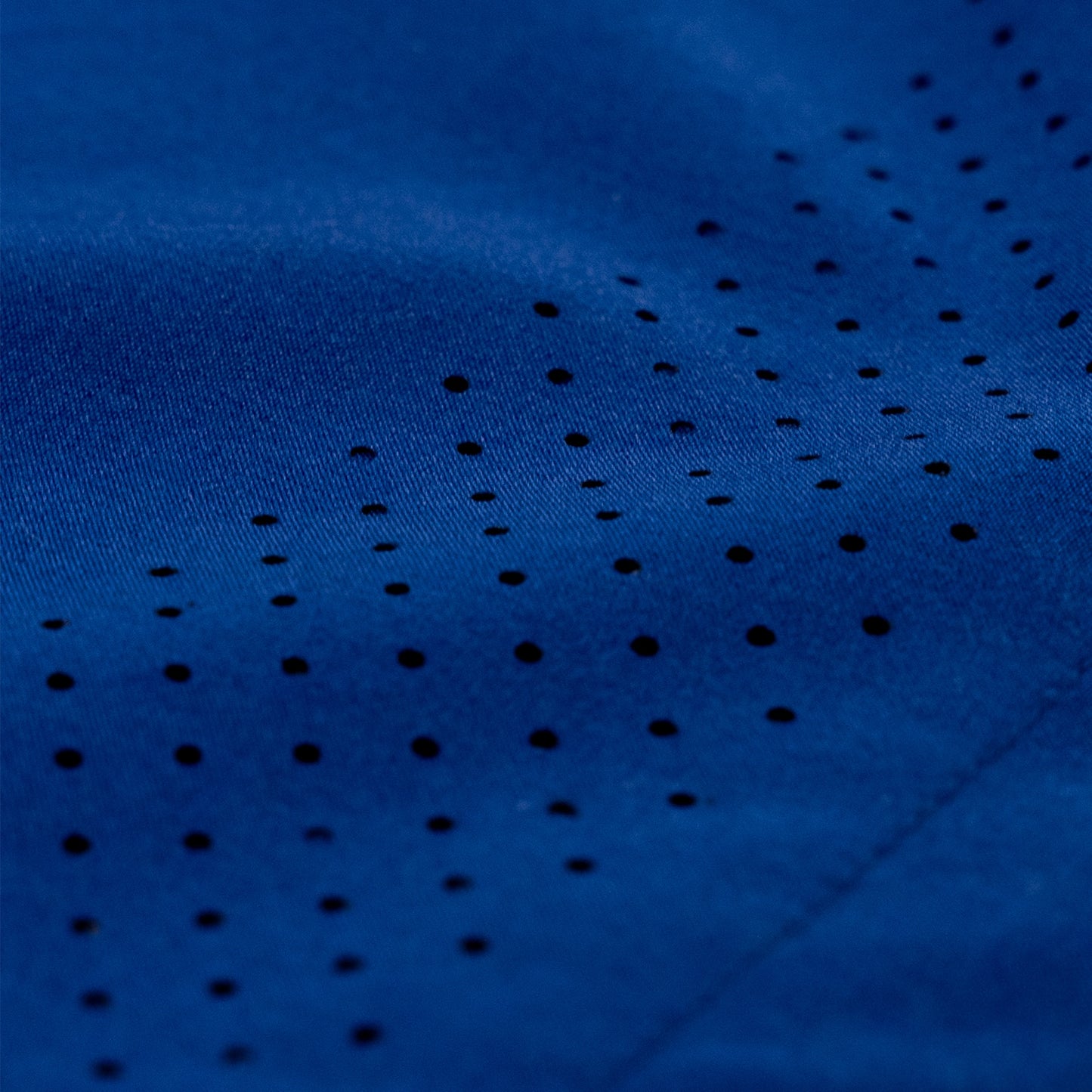 Close-up of a dark blue athletic fabric with a pattern of small perforated holes.