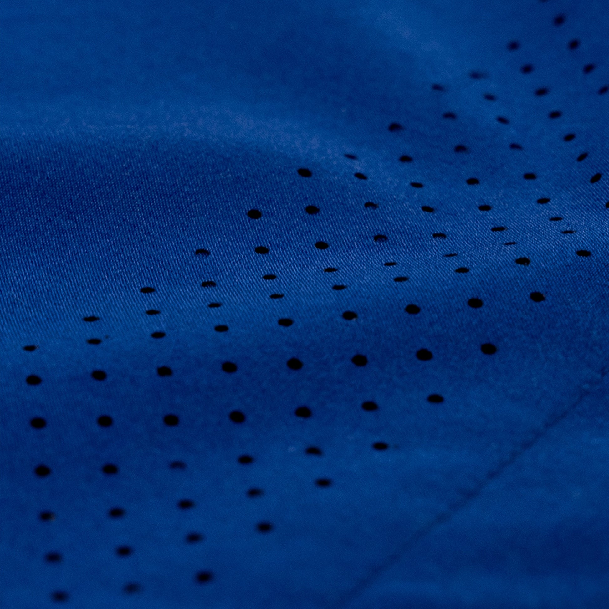 Close-up of a dark blue athletic fabric with a pattern of small perforated holes.