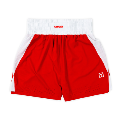 Red and white athletic shorts with a white elastic waistband featuring the red 'YAMMY' brand logo. The side panels are white mesh, and a small white geometric logo is printed on the lower left leg.