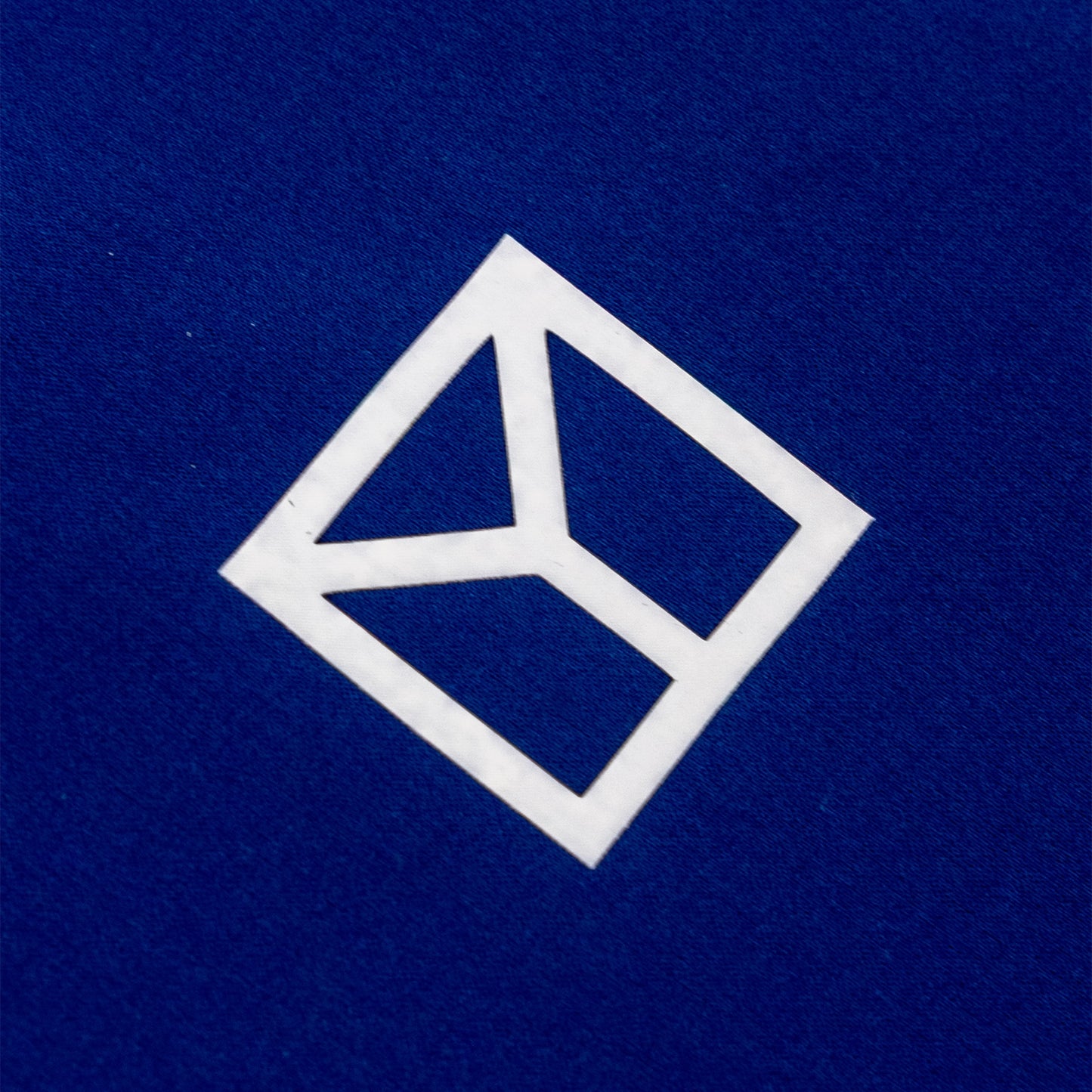 A white geometric logo decal or sticker on a textured dark blue background.