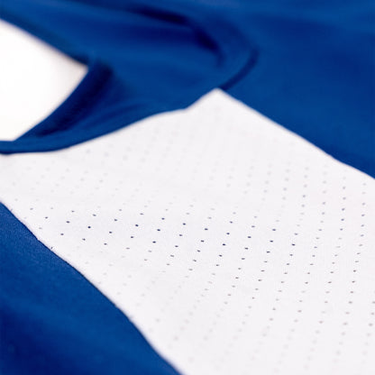 Close-up of a blue athletic jersey with a white perforated mesh chest panel.
