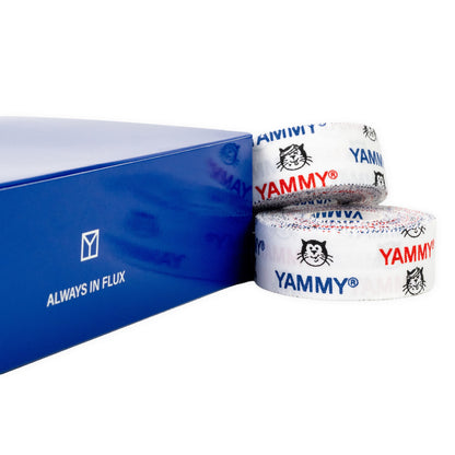 Two rolls of white athletic tape with blue and red YAMMY branding and Hector cat logos, shown next to a blue product box on a white background.