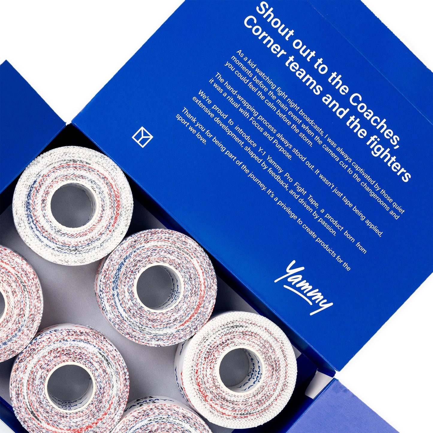 Open blue Yammy brand box showing several rolls of athletic corner tape with a white base and red and blue speckled pattern, with printed promotional text on the inner lid.