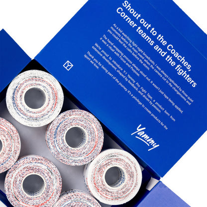 Open blue Yammy brand box showing several rolls of athletic corner tape with a white base and red and blue speckled pattern, with printed promotional text on the inner lid.
